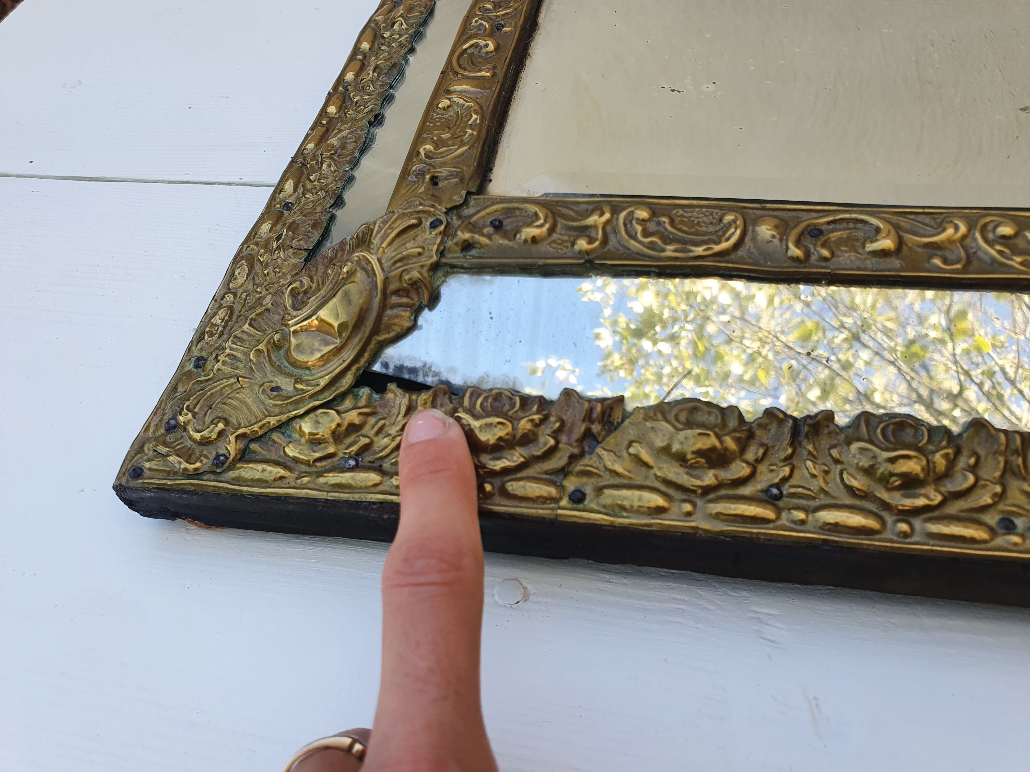 Miroir à parecloses en bois doré et métal repoussé
