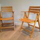 Pair of varnished wooden folding armchairs signed Clairitex.