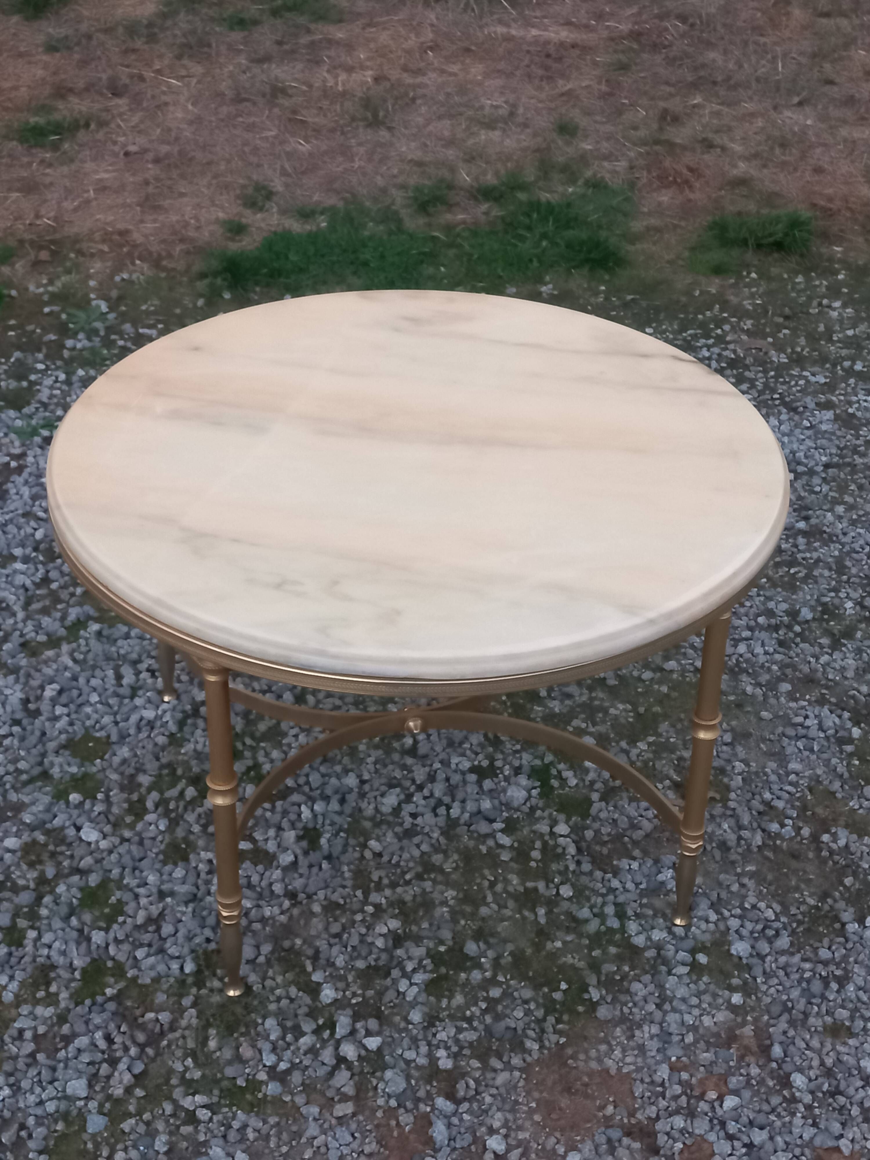 Round neoclassical coffee table with a marble top and golden metal base.