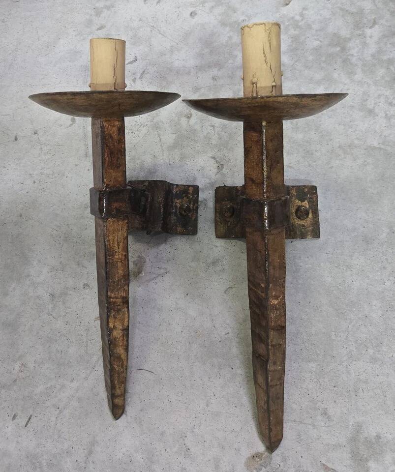 Pair of brutalist wall sconces in hammered and patinated iron, work from the years.
