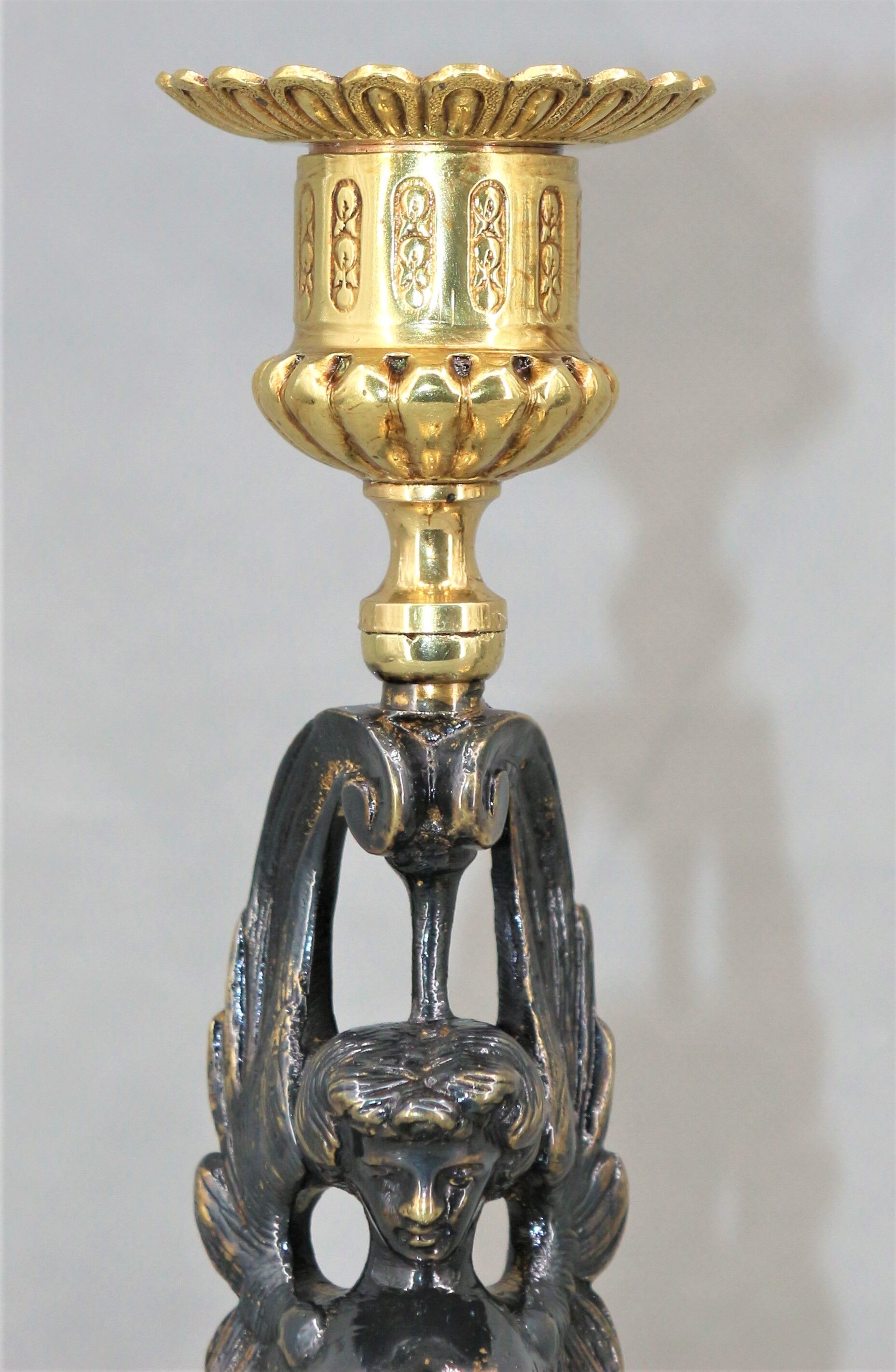 Pair of candle holders in gilded bronze and patinated with a candle