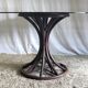 Round dining table tulip foot in rattan and smoked glass 70s
