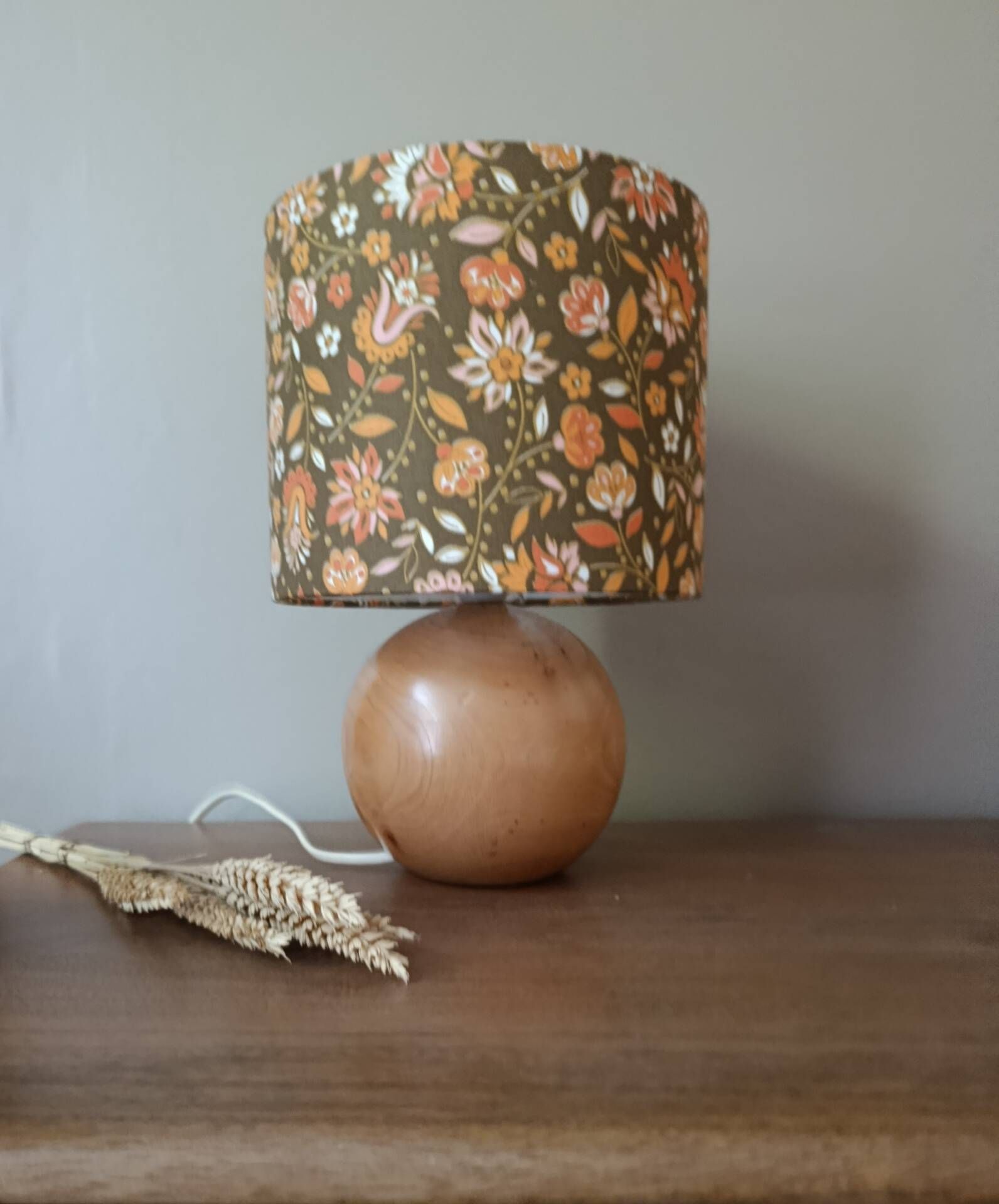 Table lamp with a wooden ball base, floral print in bohemian style.