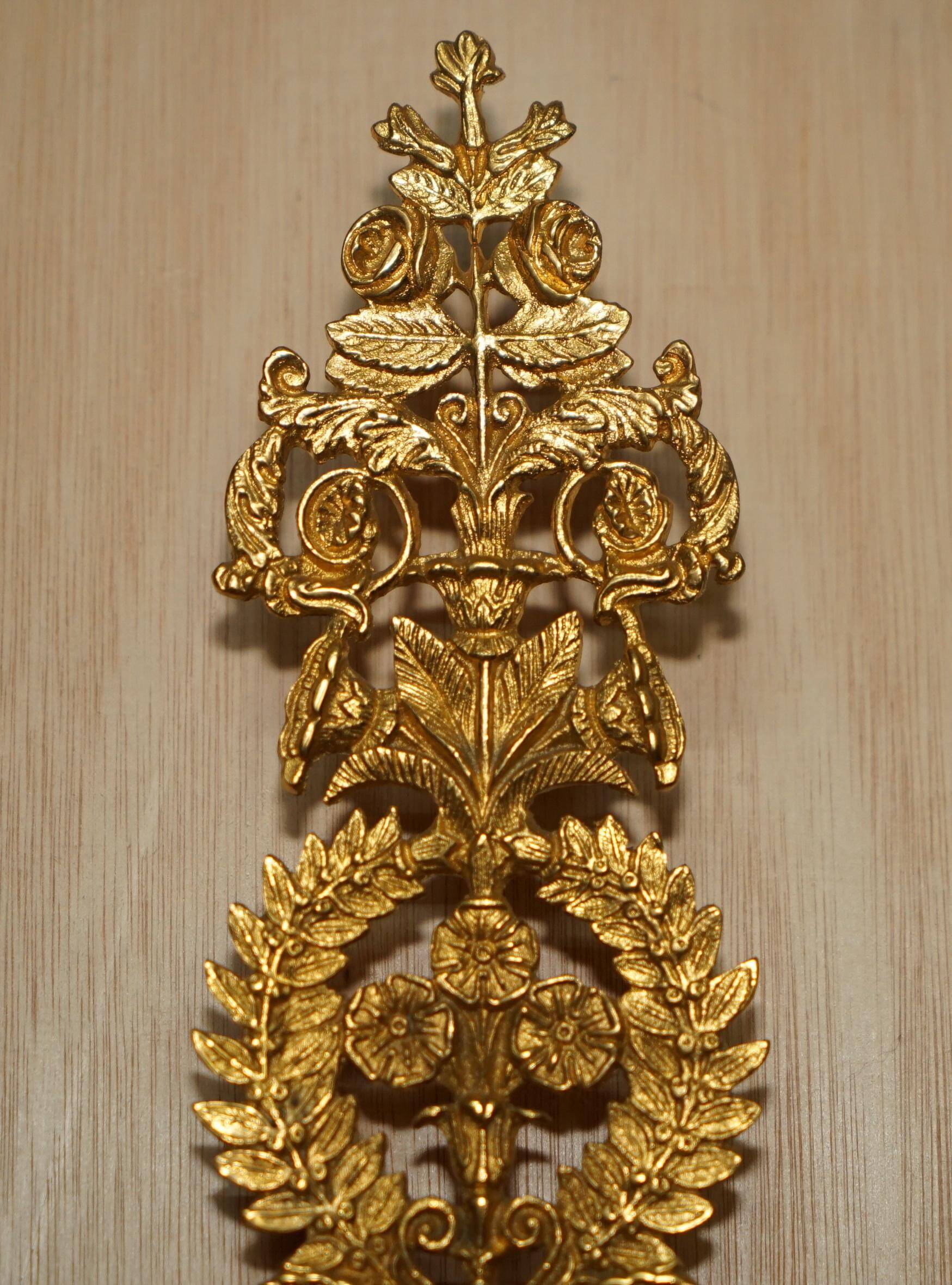 Pair of L'Originale wall sconces plated with 24-carat gold featuring four bronze candles.
