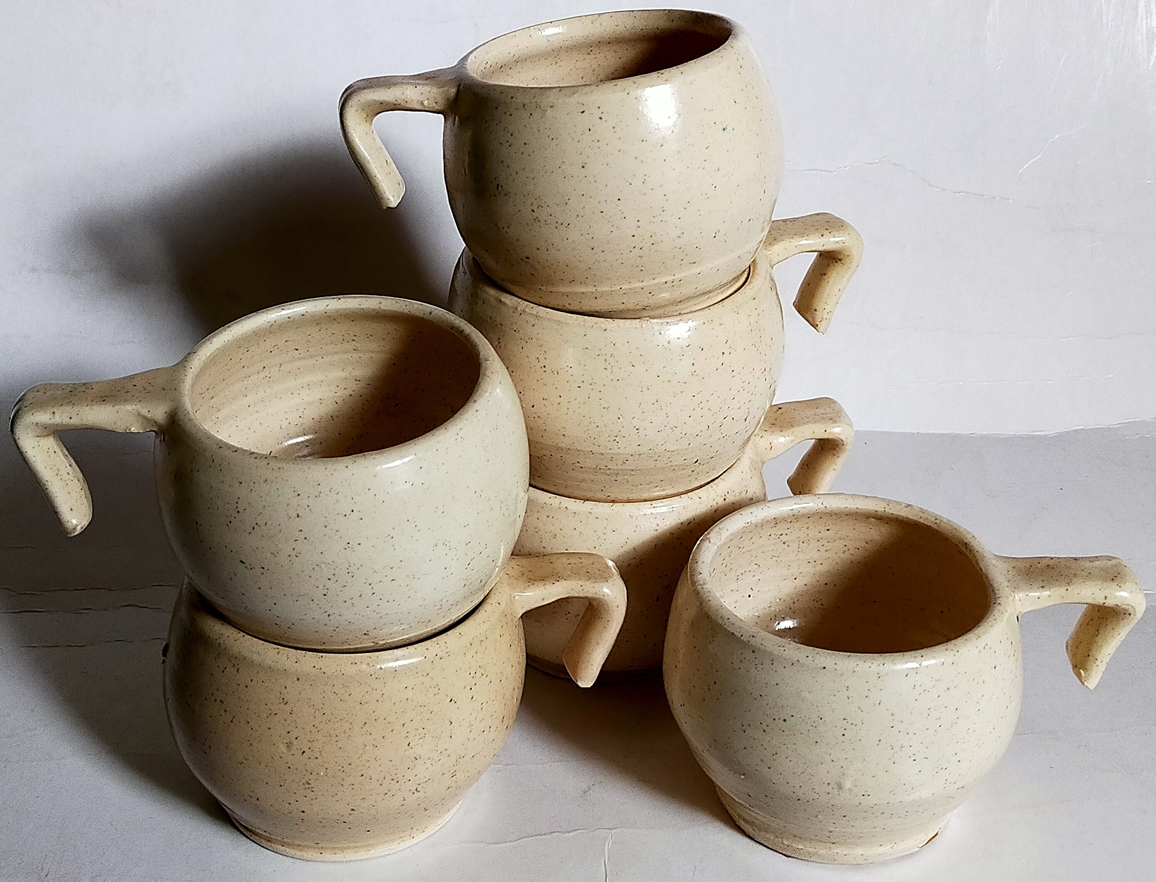 Six vintage potter's ceramic cups with vanilla enamel