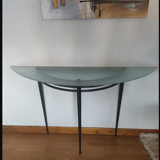 Half-moon console with glass top resting on three tapered legs in black lacquered metal ARTELANO
