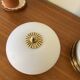 Pair of antique half-spherical ceiling sconces in white glass and brass.