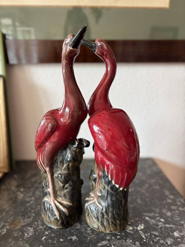 Paire de statuettes d’échassiers (grues) en céramique émaillée rouge