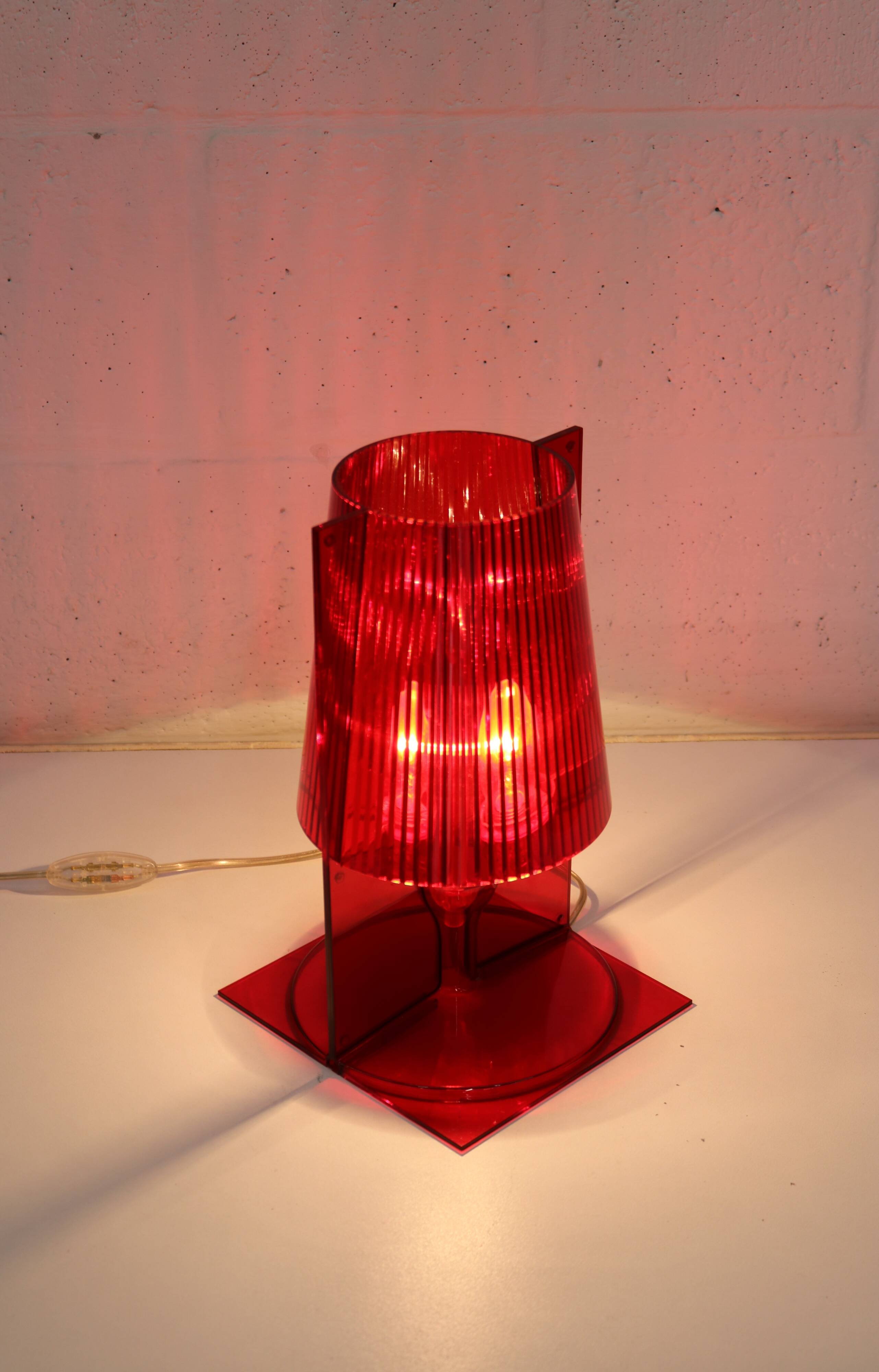 Red plastic Kartell table lamp - model Take - design by Ferruccio Laviani