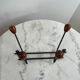 Wall-mounted coat rack in wrought iron with turned wooden knobs.