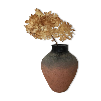 Terracotta vase with gradient of black faded to half on an earth-colored background