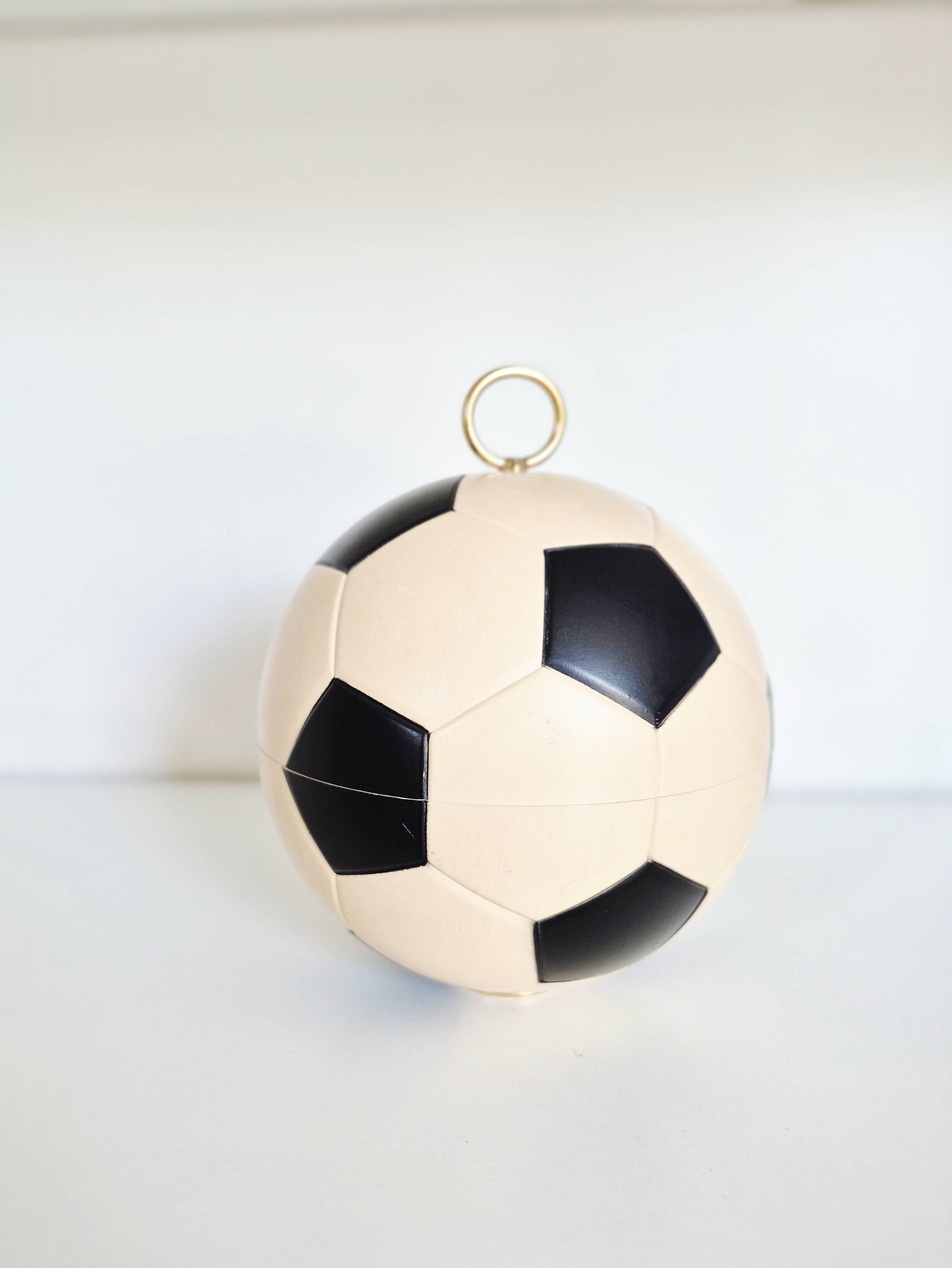 Vintage cigarette dispenser in the shape of a football.