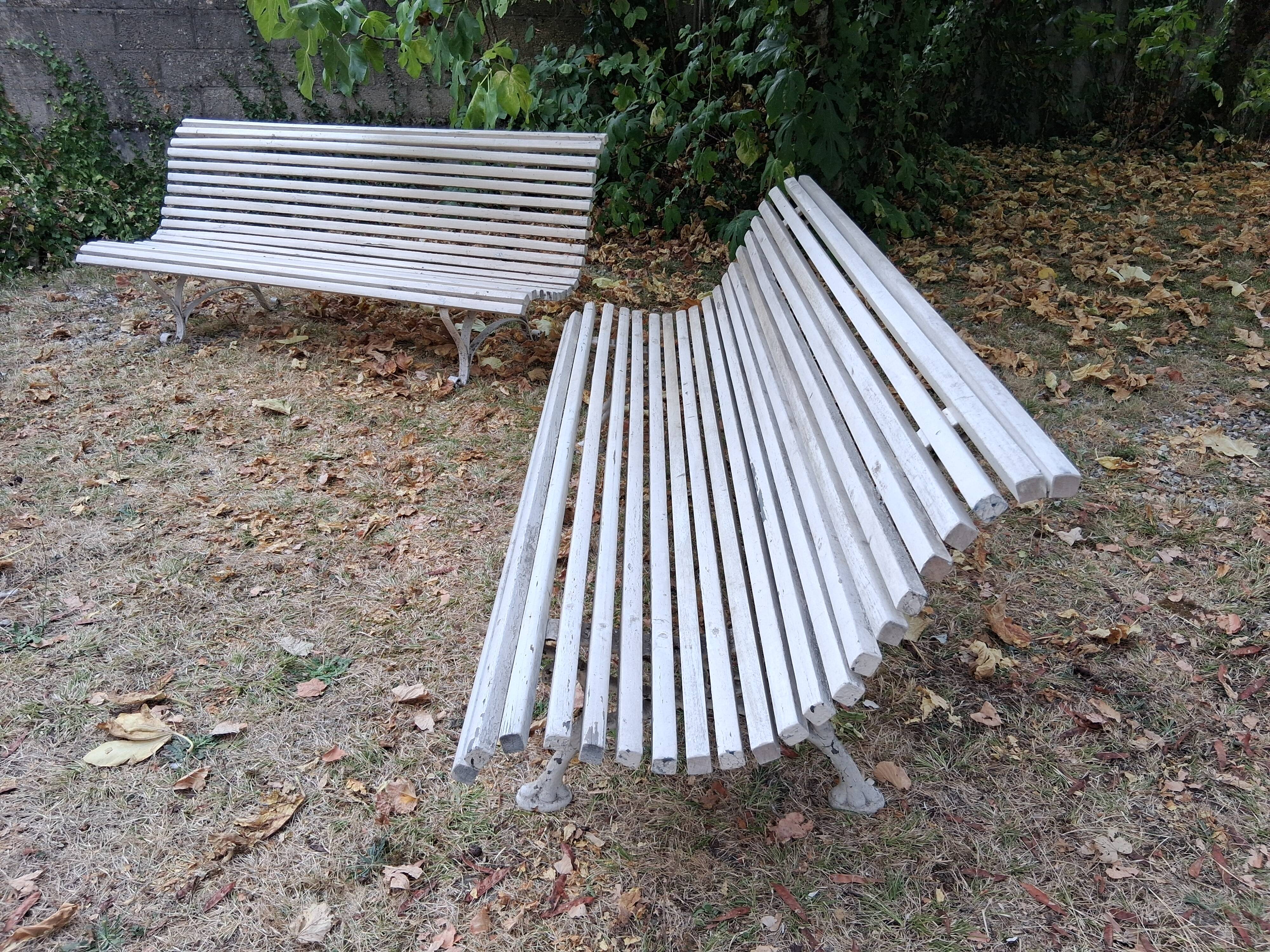 Pair of antique wooden slatted benches with wrought iron legs.