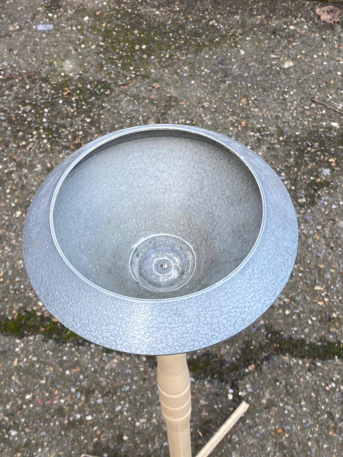 Vintage ashtray on a beige and grey metal stand.
