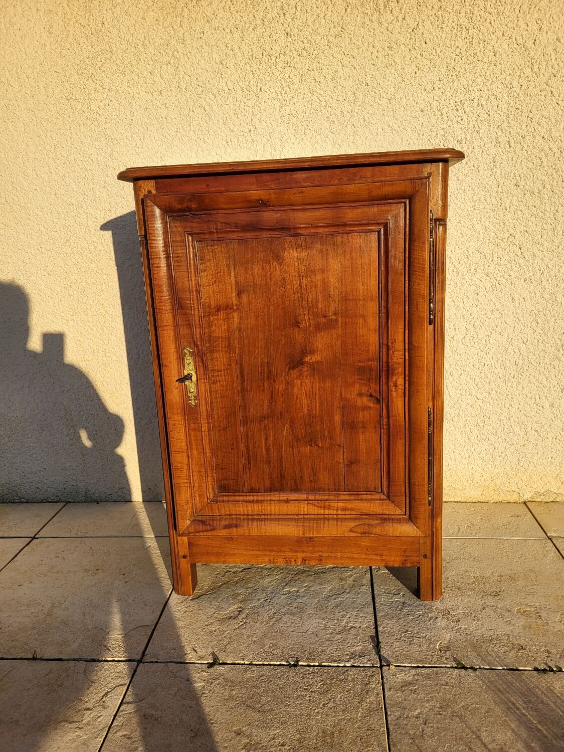 Furniture with a cherry wood door.