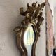 Antique rococo mirror with putti, gilded carved wood and stucco frame, 19th century.