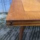 Table vintage portefeuille en chêne aux pieds compas.