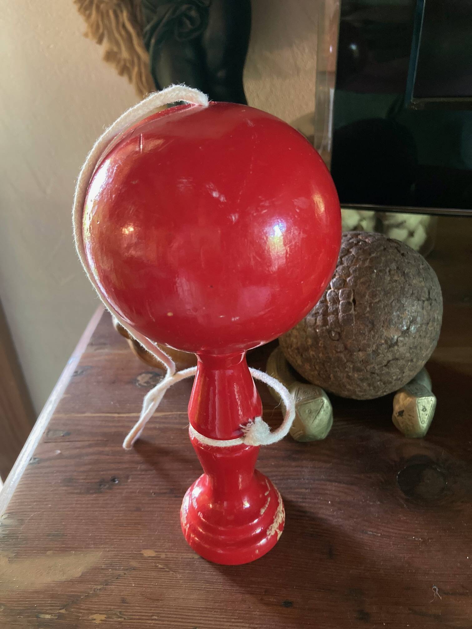 Large red wooden cup-and-ball game, 9 cm in diameter.
