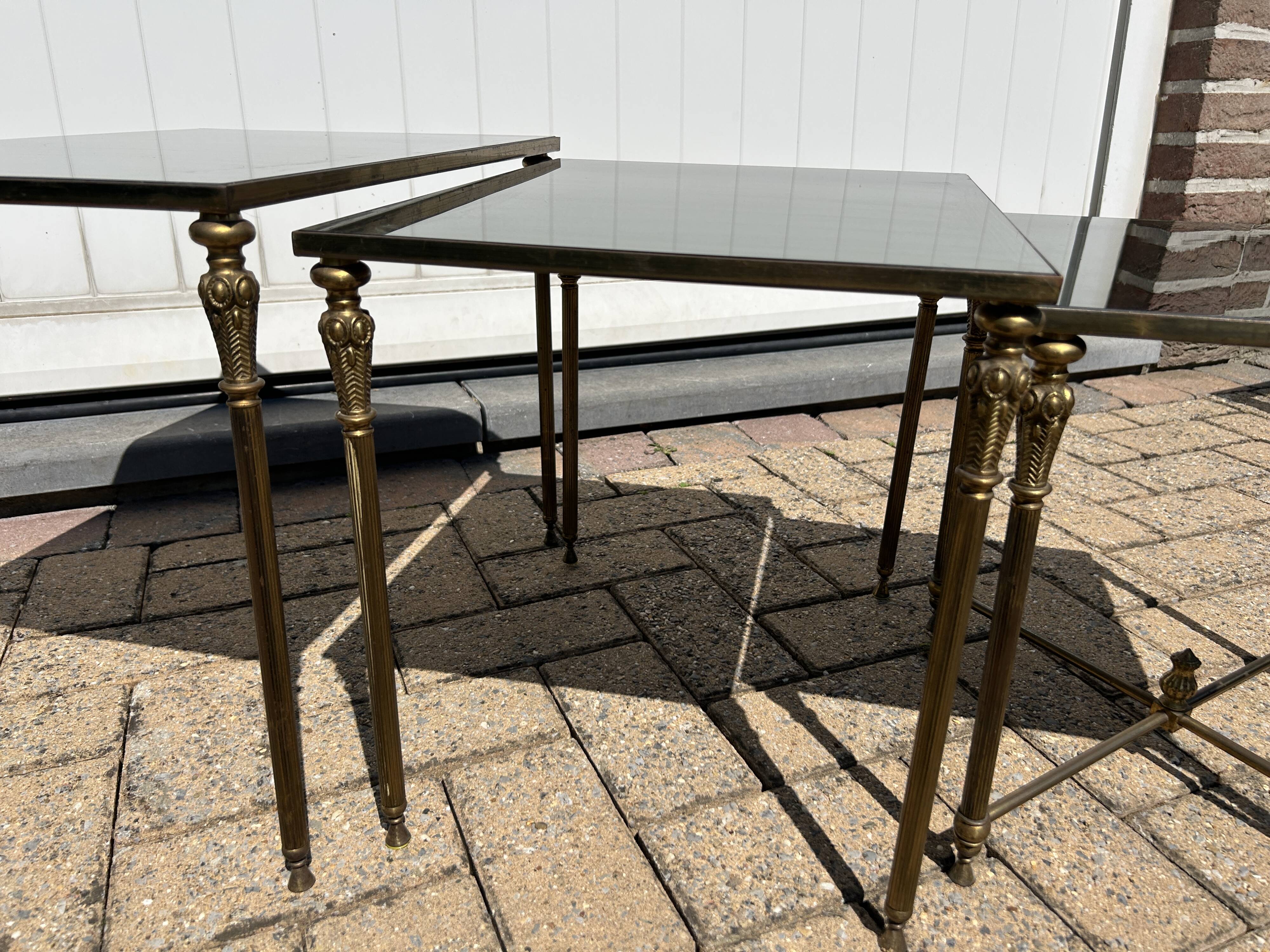 Nested tables in gilded brass in the style of Maison Charles.