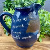 Blue ceramic pitcher with vintage artisan inscription decoration.