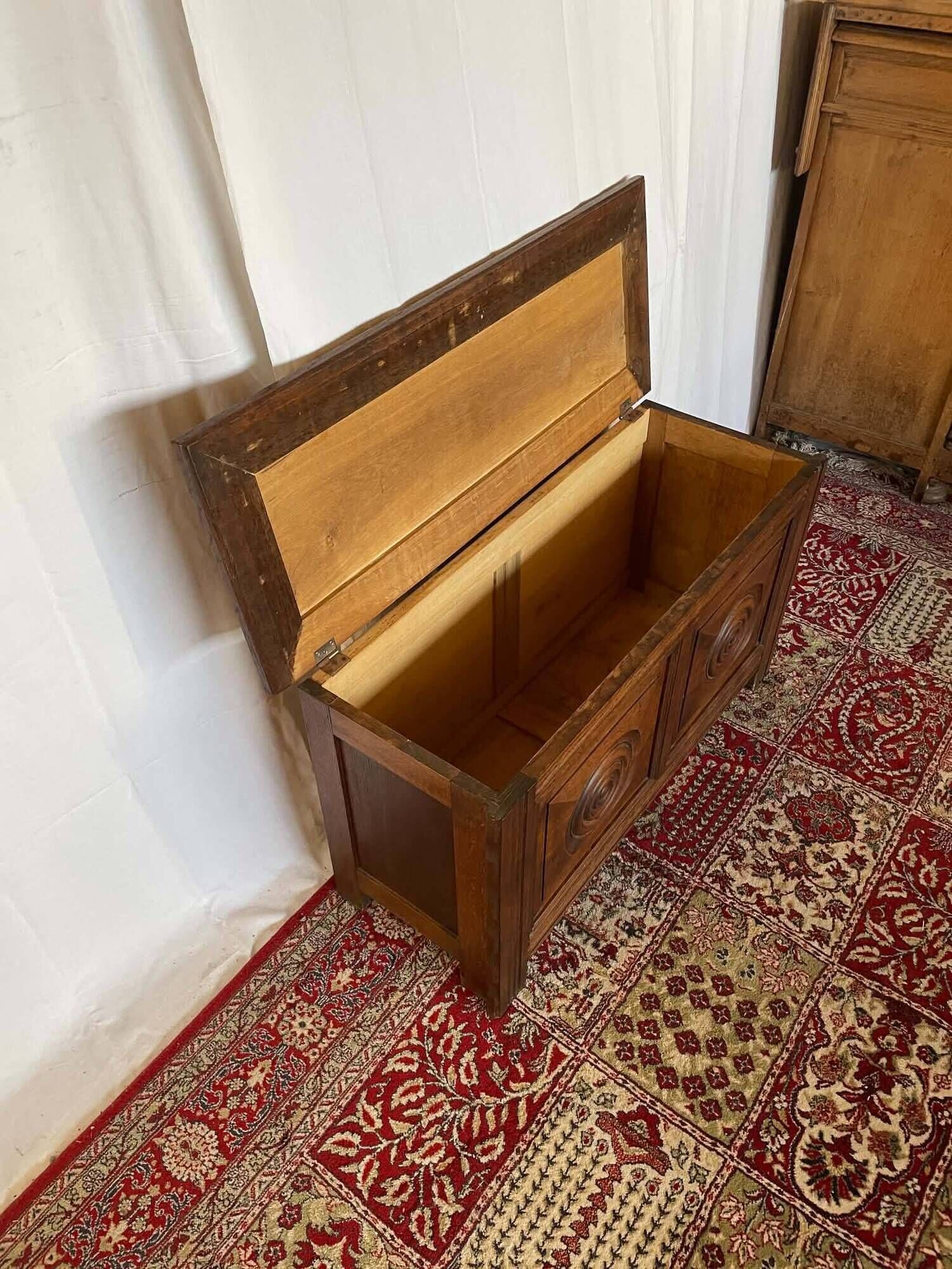 Small antique oak chest with carved panels.