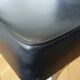 Chrome metal chairs and black faux leather upholstery in retro modernist style.