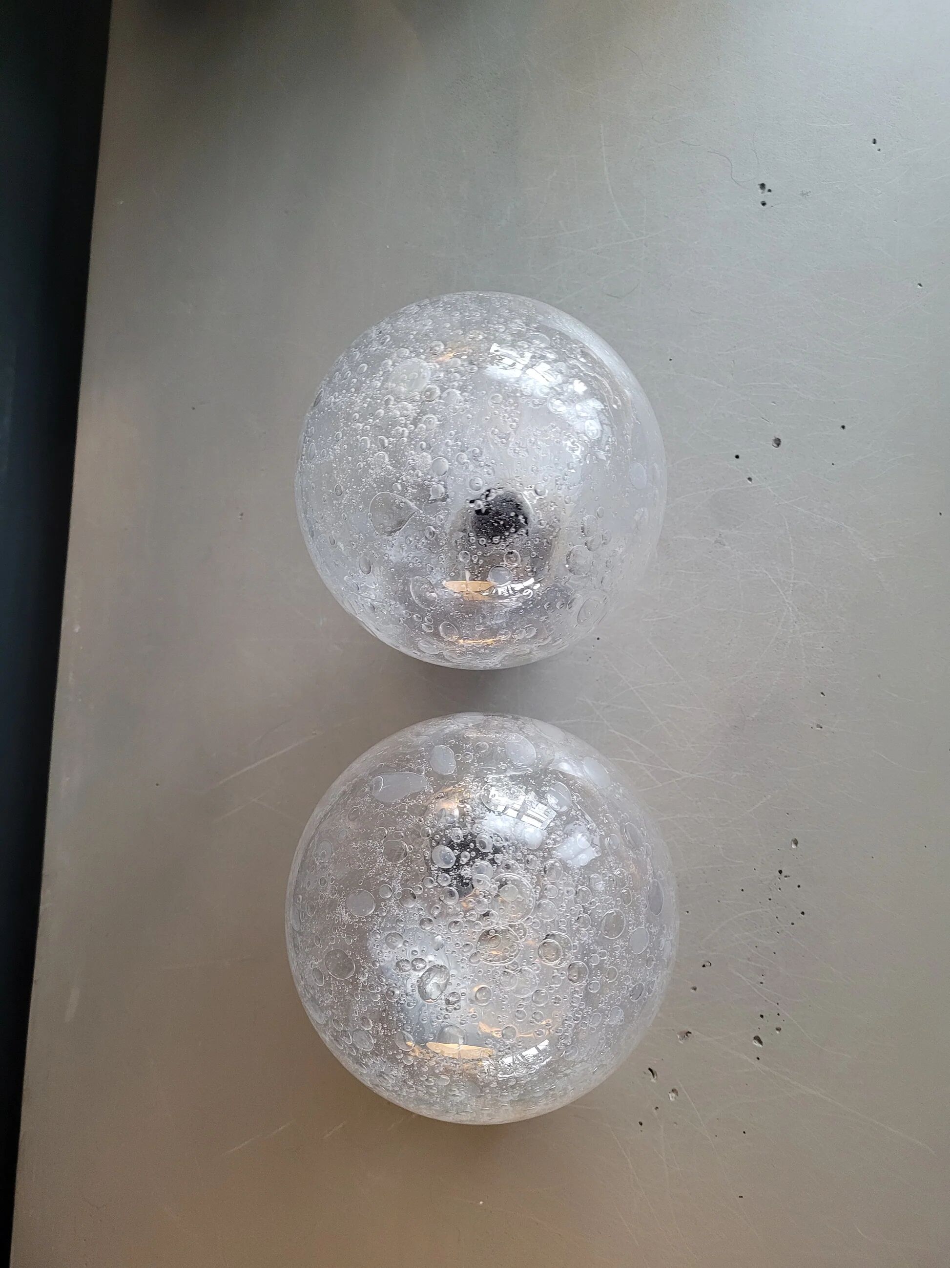 Pair of vintage wall lights in chrome metal with bubbled glass globes.