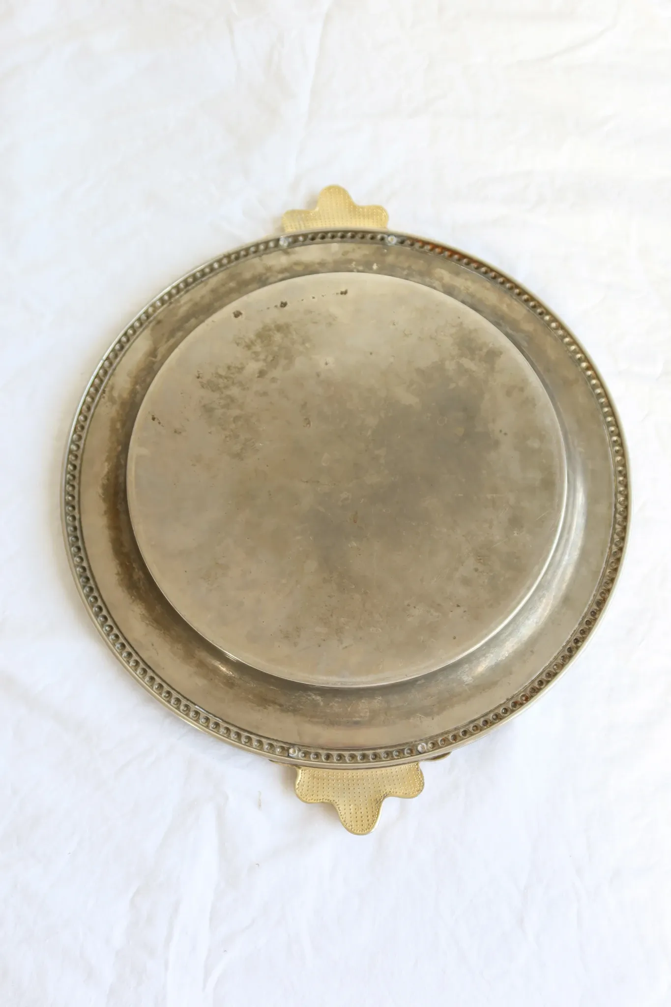 Vintage silver-plated serving tray with bow handles.