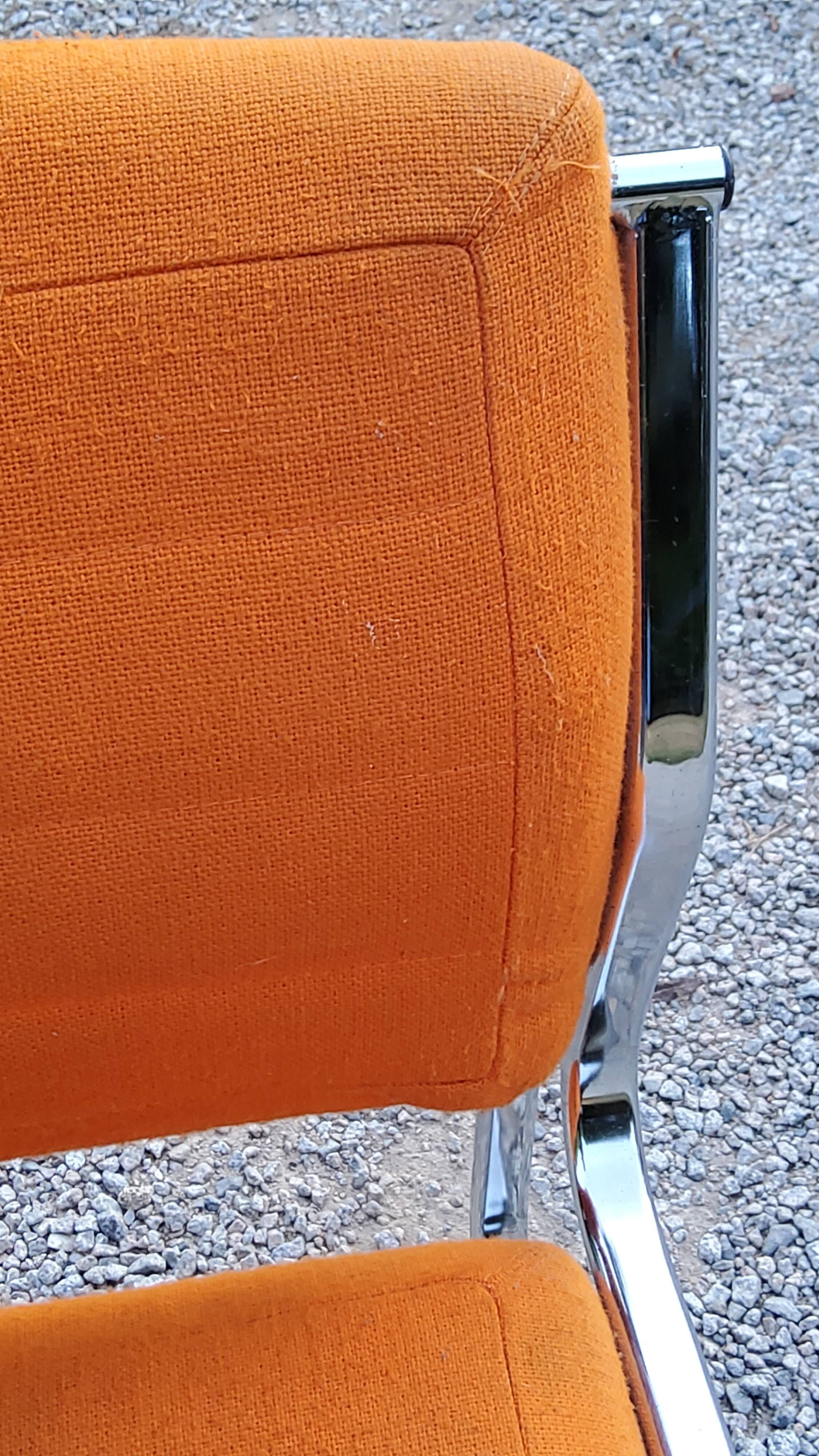 Pair of designer armchairs in orange fabrics and chrome tubes from the 70s