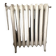 Radiateur ancien sur pieds à huit lames fleuries en fonte de fer XX siècle