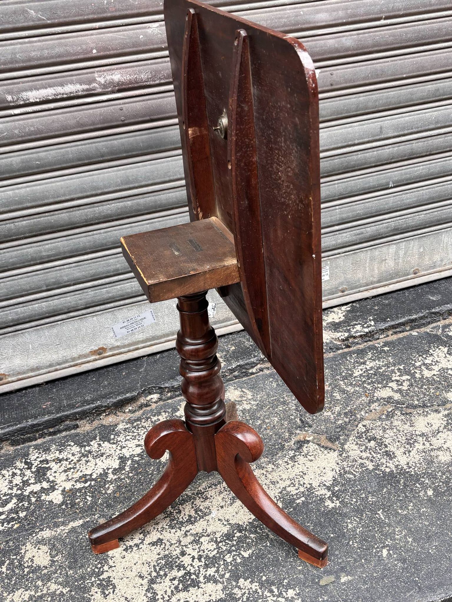 19th-century solid mahogany table with a tilting top and brass mechanism.