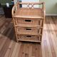Small storage unit / freestanding shelf in light rattan.