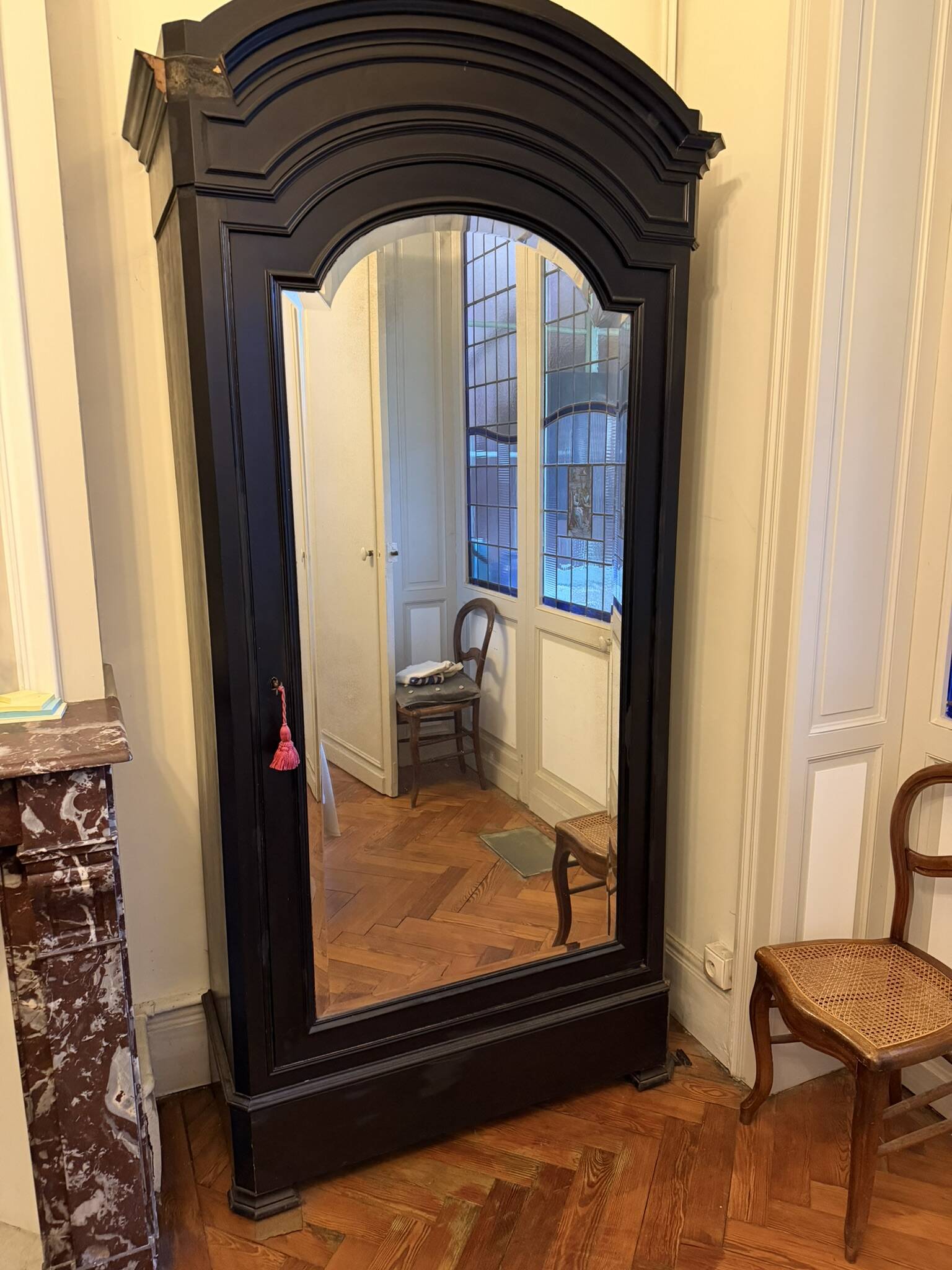 Black wardrobe with a mirrored door in ebony finish.