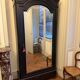 Black wardrobe with a mirrored door in ebony finish.