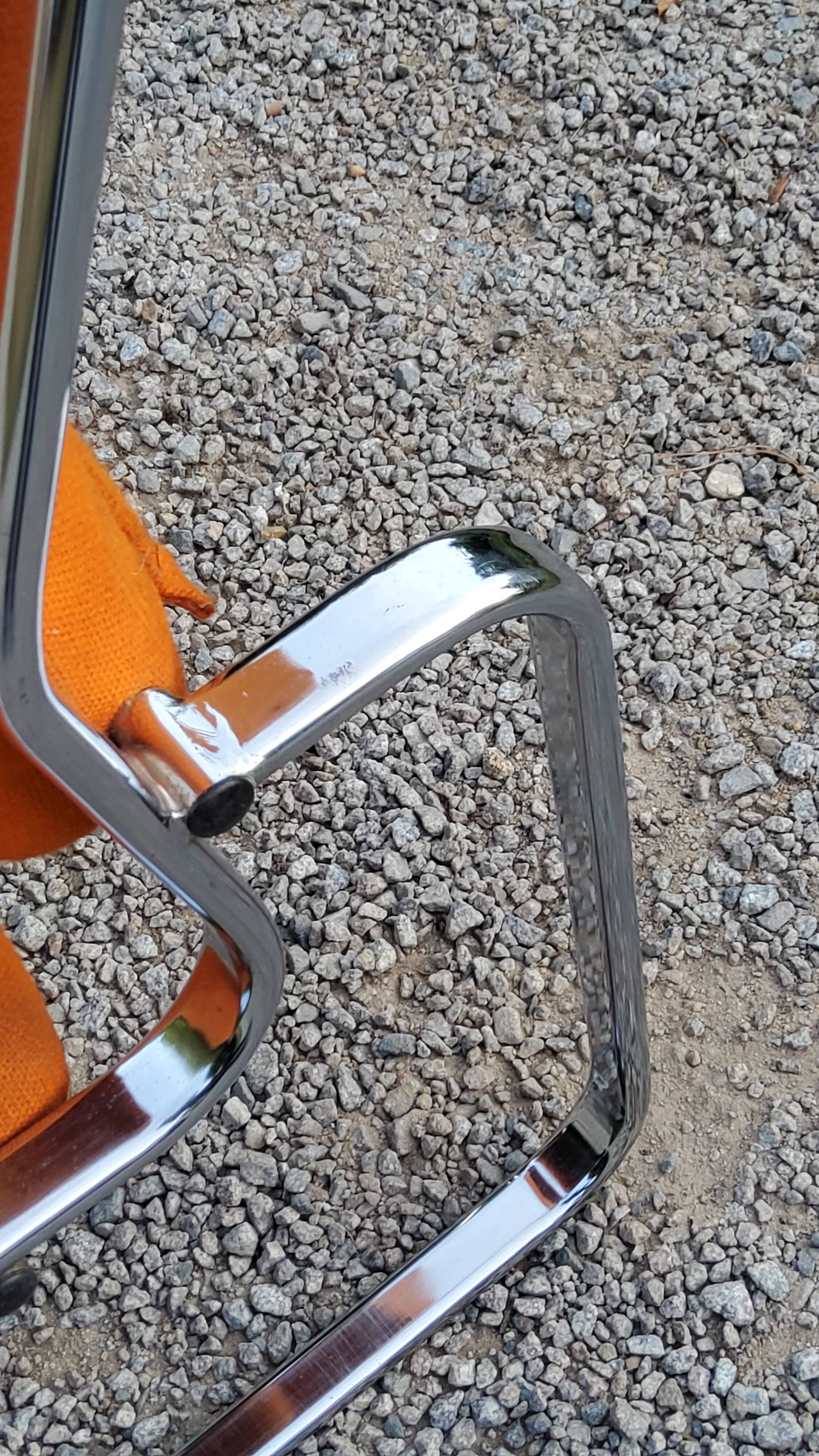 Pair of designer armchairs in orange fabrics and chrome tubes from the 70s