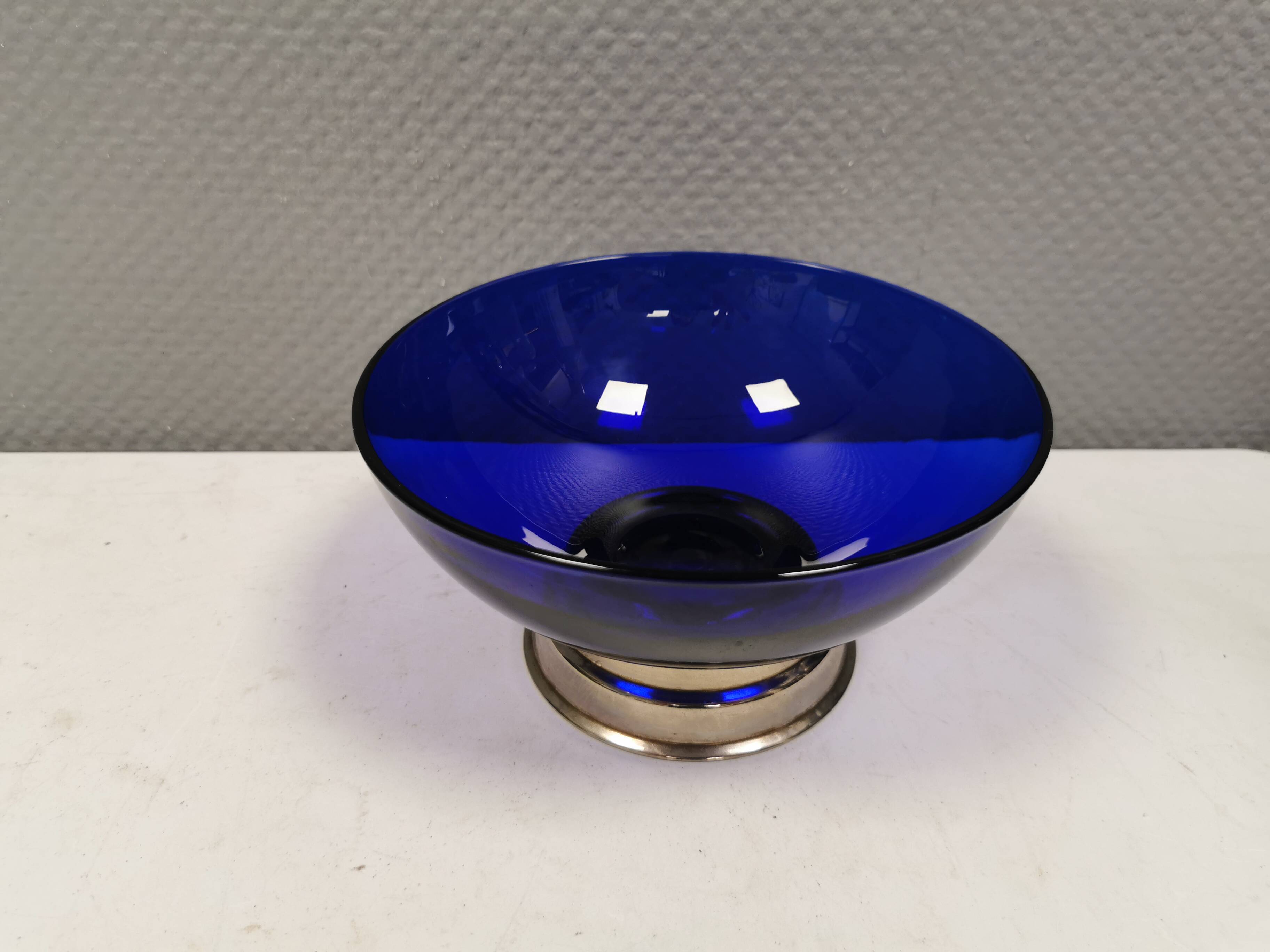 Beautiful blue glass bowl mounted on silver colored base (Original).