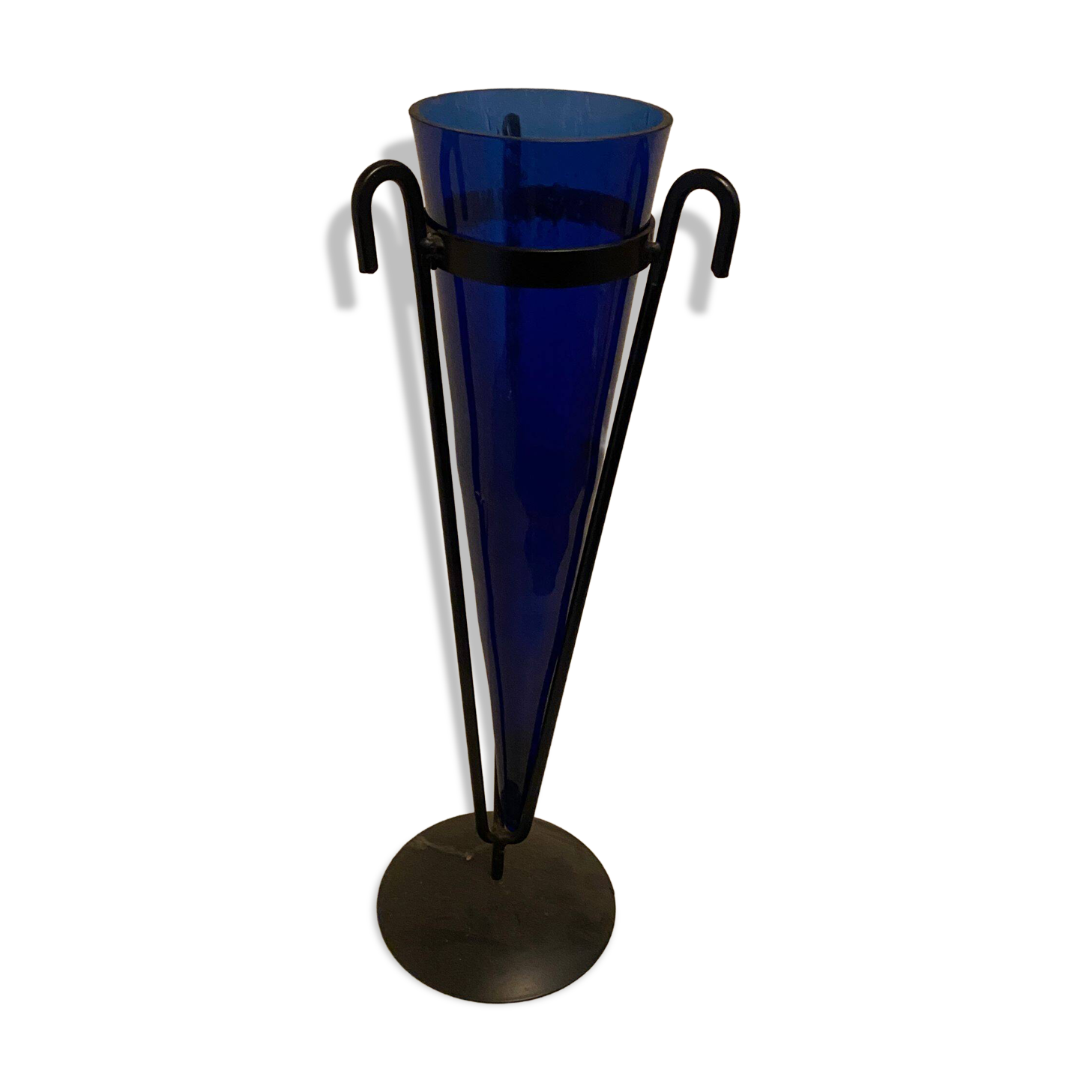 Cobalt blue vase on a metal structure.