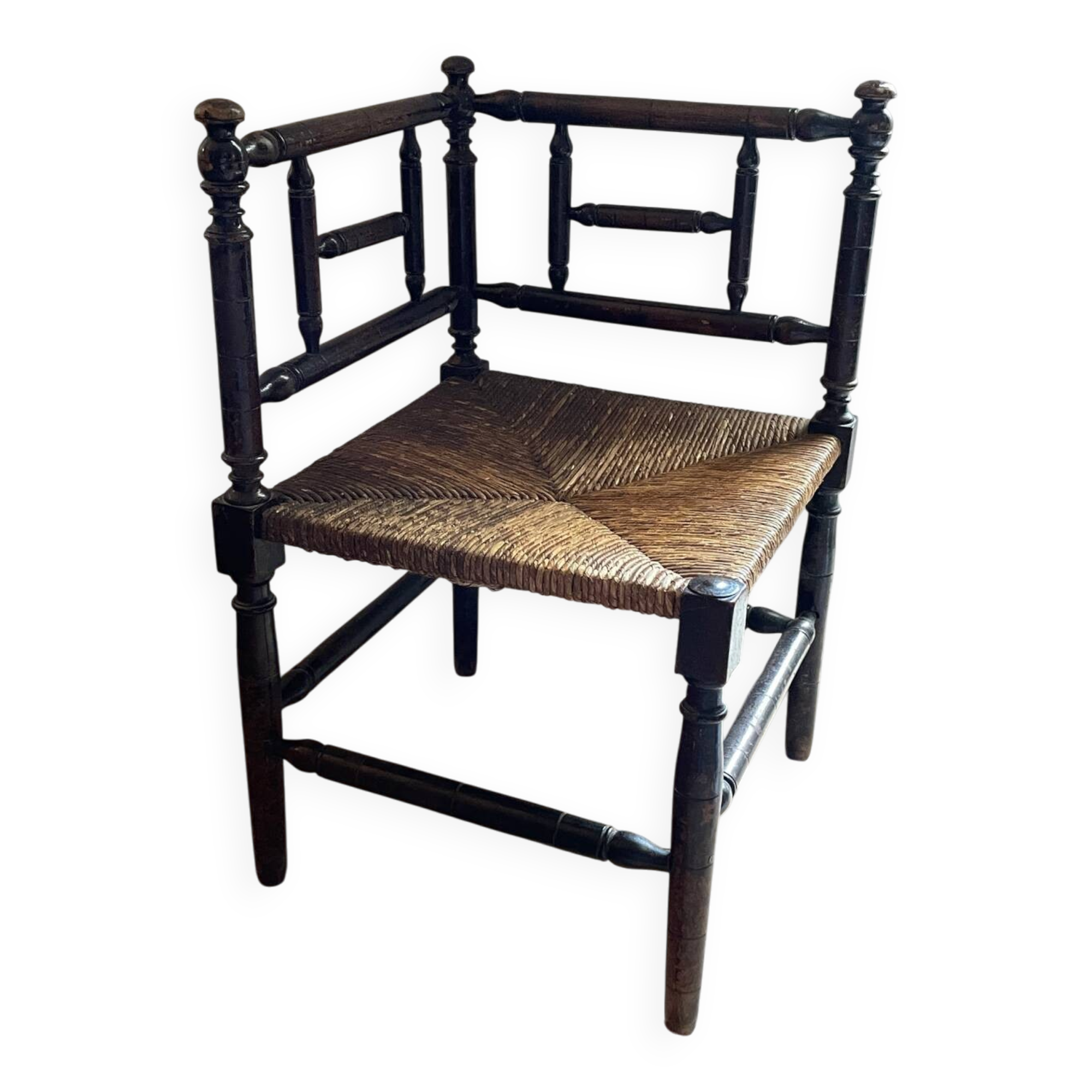 Corner chair made of turned wood with a straw seat.