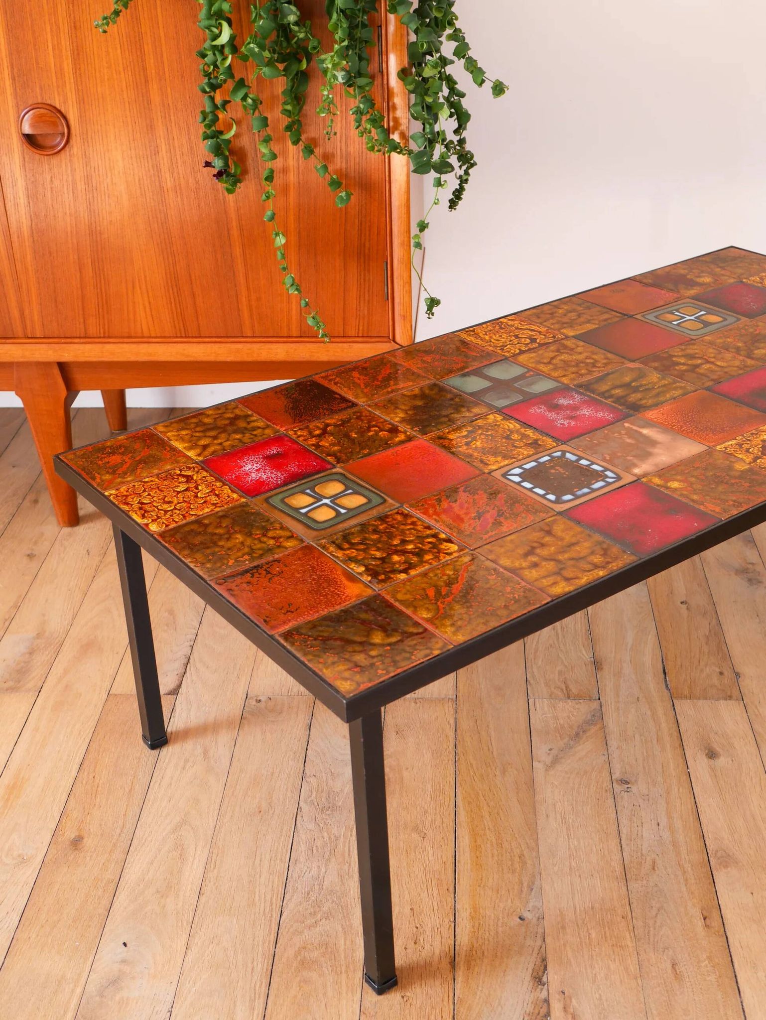 Ceramic and black iron coffee table, attributed to the Roche-Bobois brand, with a black metal base and structure, rectangular ceramic top from Vallauris with colourful patterns in ochre and orange, design from the 1970s.