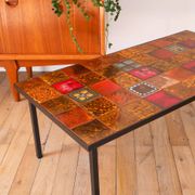 Ceramic and black iron coffee table, attributed to the Roche-Bobois brand, with a black metal base and structure, rectangular ceramic top from Vallauris with colourful patterns in ochre and orange, design from the 1970s.