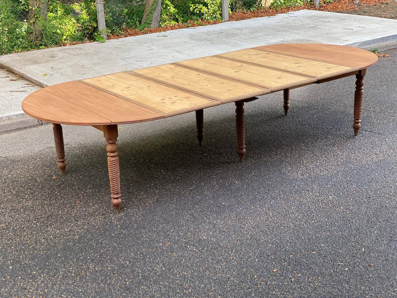 Round extendable banquet table stripped in solid mahogany with 4 extensions, 19th century.