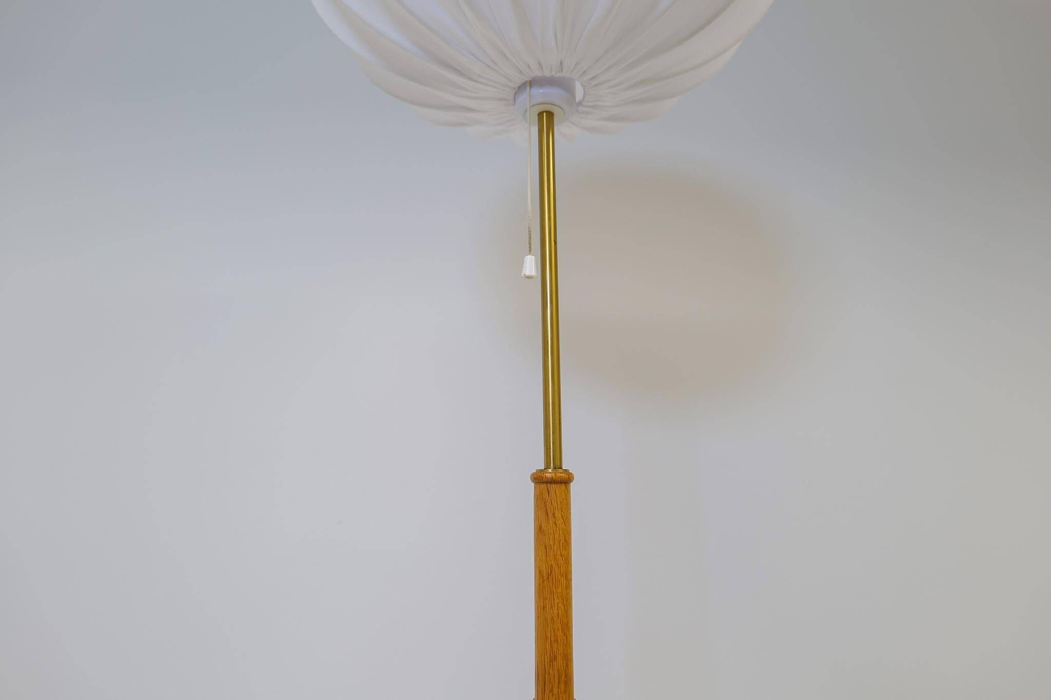 Mid-century floor lamp in brass and oak by Falkenbergs Belysning, Sweden, 1960s.