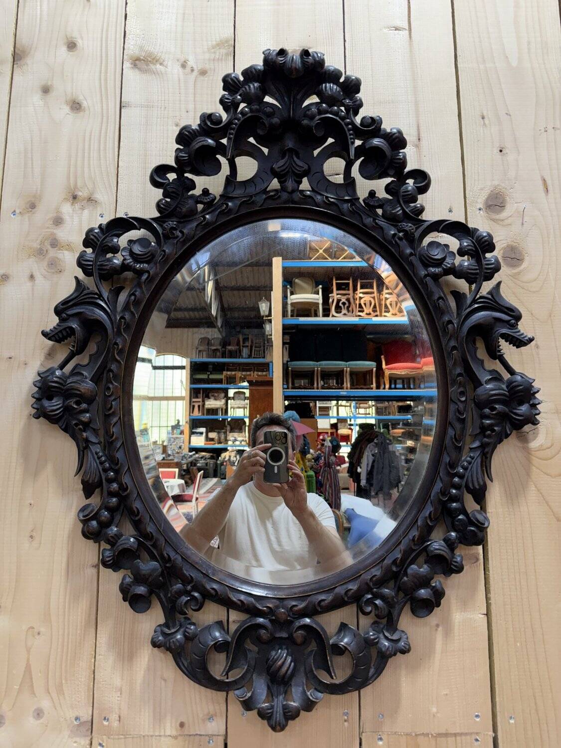 Oval mirror in carved wood with dragon heads.