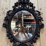 Oval mirror in carved wood with dragon heads.