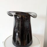 Large black glass vase topped with a 70s hat