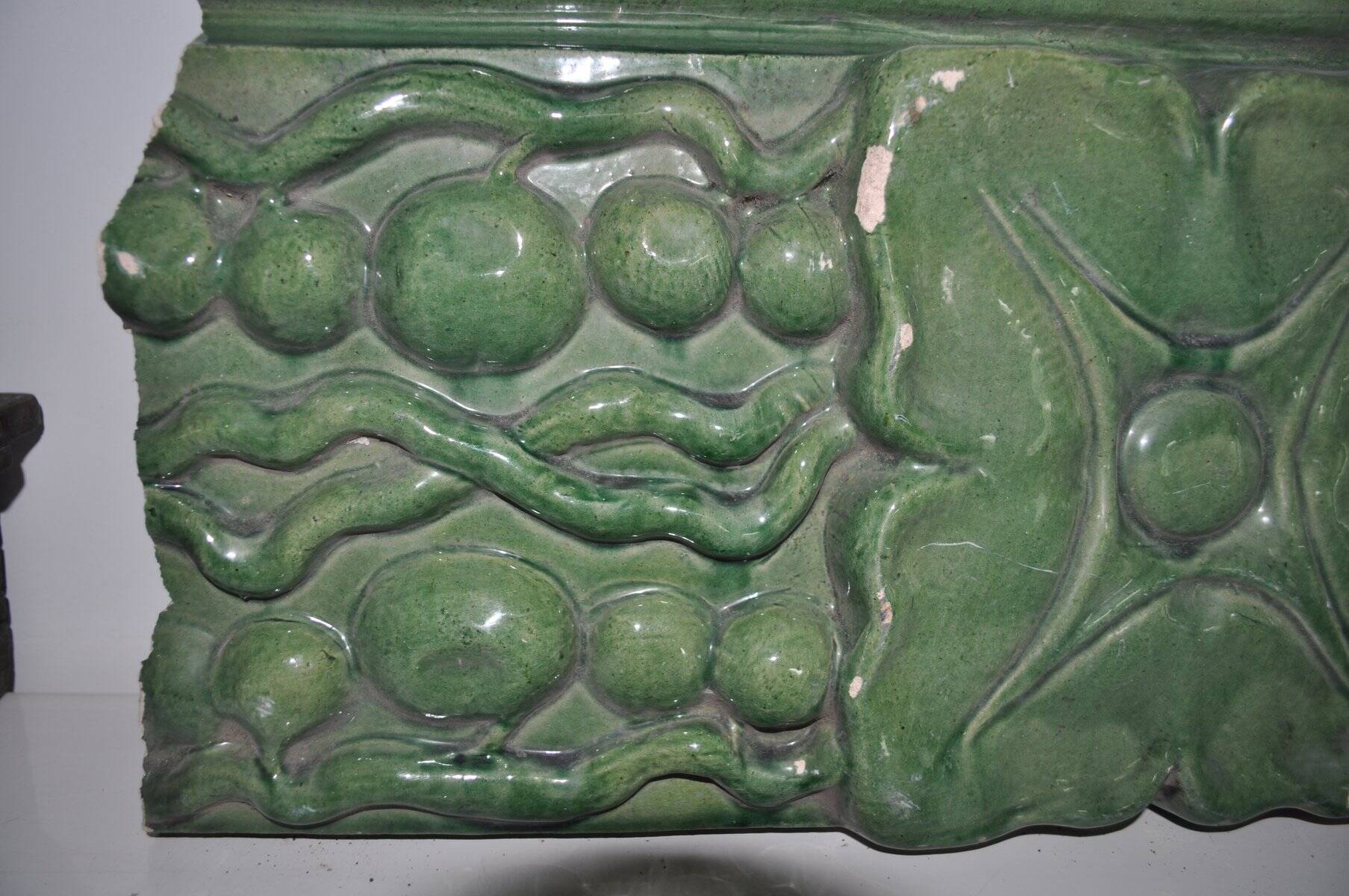 Green enamelled ceramic stove tile — finely sculpted Hungarian pattern from the late 19th century.