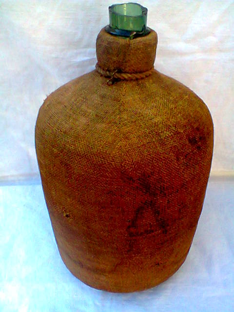 Demijohn dressed in burlap and padded cork
