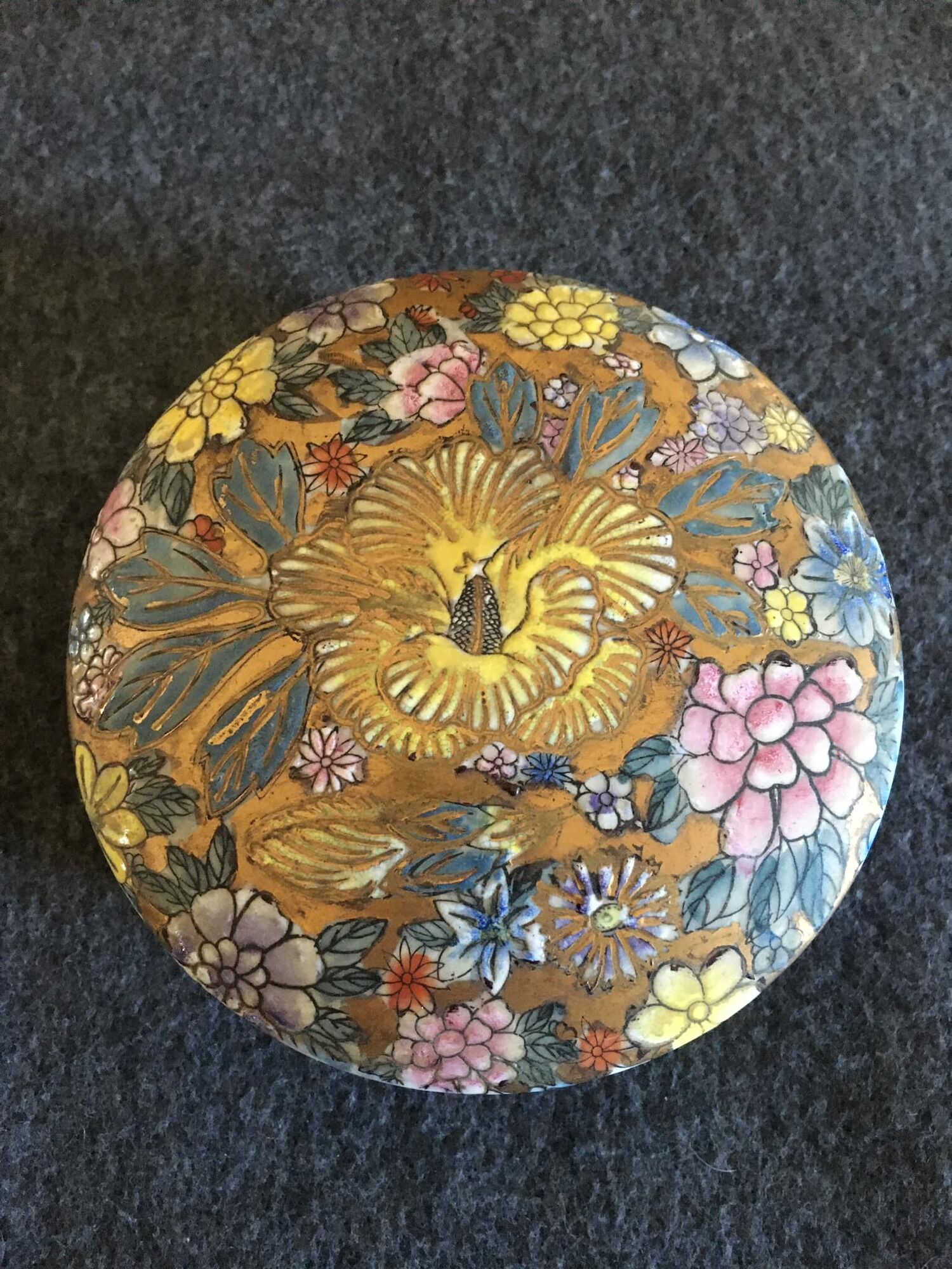 Porcelain candy with enamelled floral decorations. Pretty colors on a golden background.