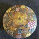 Porcelain candy with enamelled floral decorations. Pretty colors on a golden background.