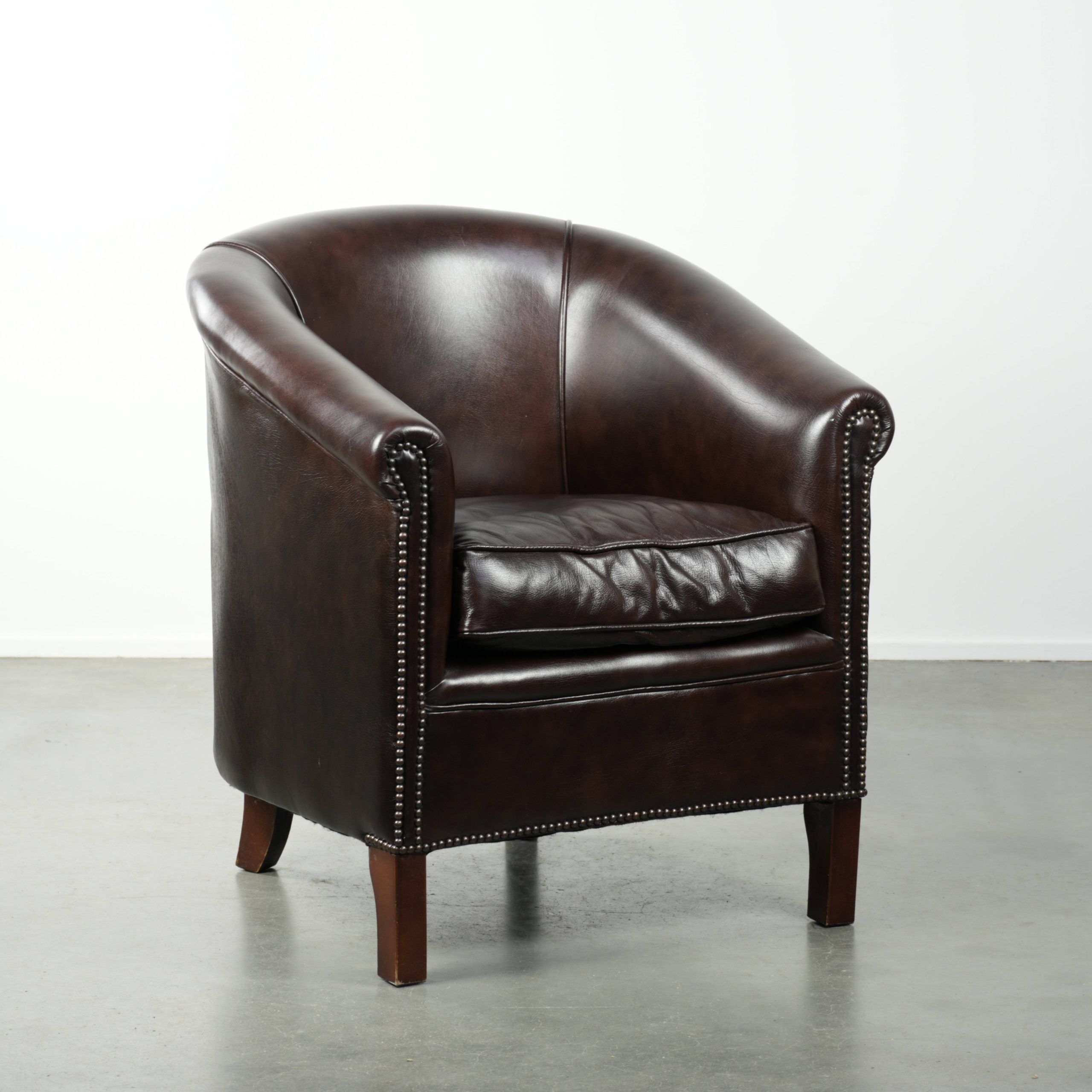 Dark cow leather club armchair with a stylish design in English style